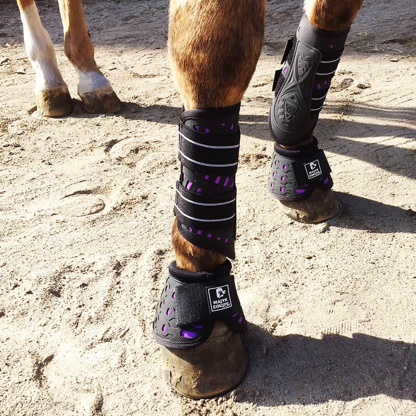 Majyk Equipe Over Reach No Turn Notch Boot with Impact Protection – Pair on a horse's legs in sandy arena.